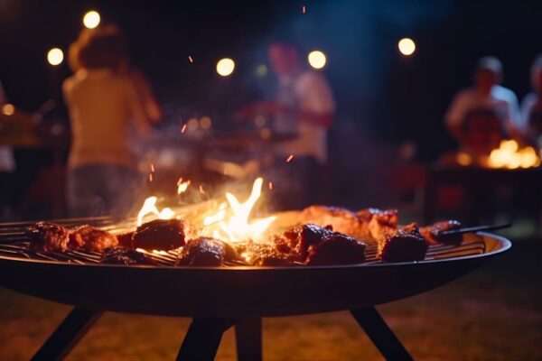 Cooking meat on charcoal grill with flames